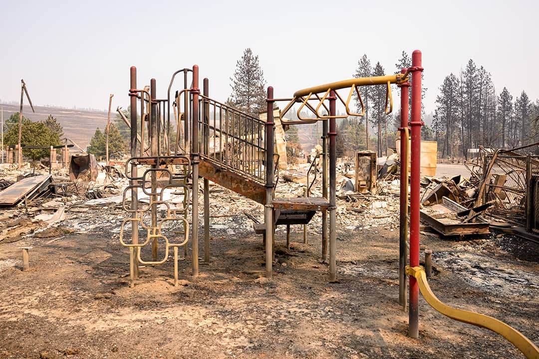 The burned remains of a playground are seen amidst the smoldering ashes of Riverside Real Life Church during the Old Trails fire in Spokane, Washington on August 4, 2026.